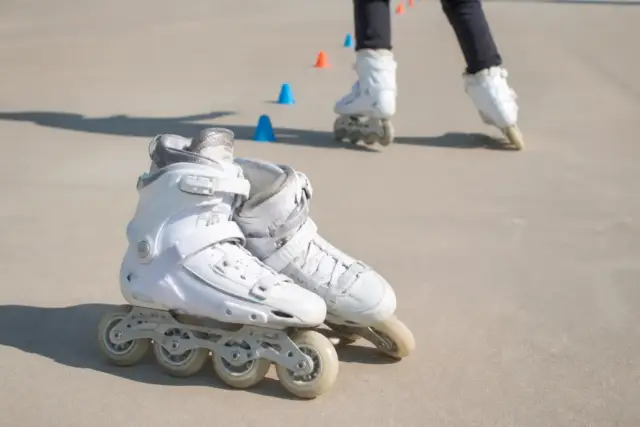 Surface lisse et dégagée, plots posés au sol en ligne, paire de patins à roulettes au premier plan