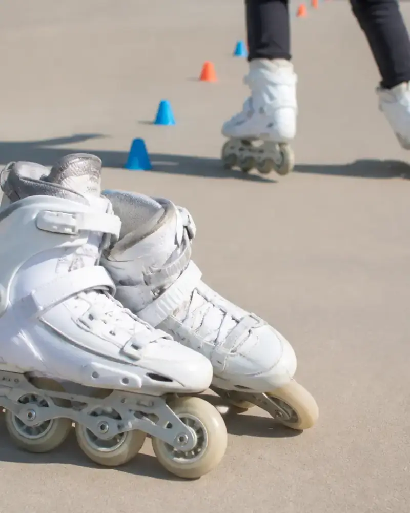 Surface lisse et dégagée, plots posés au sol en ligne, paire de patins à roulettes au premier plan