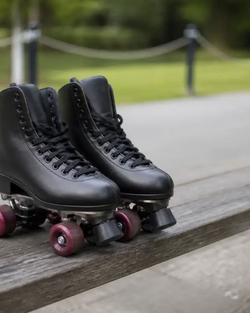 Paire de patins à roulettes à quatre roues posée sur un banc en bois, lumière douce, sans personne