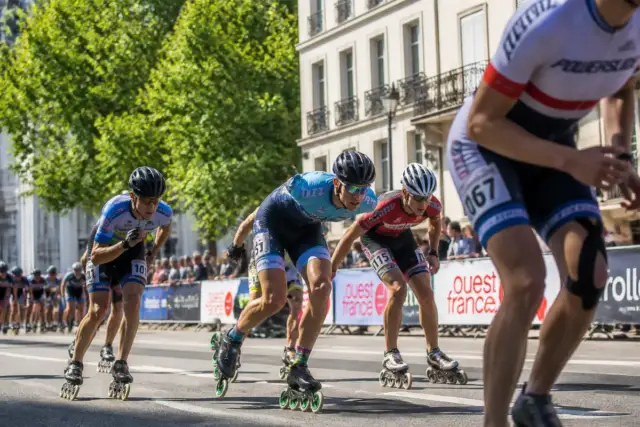 Patineurs en course pendant un marathon roller dans une rue arborée en ville
