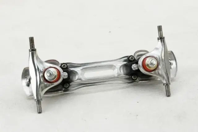 Platine de patin à roulettes vue du dessous sur un fond clair, essieux et gommes visibles, sans roues