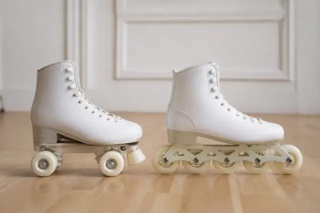 Un patin à roulettes quad et un patin en ligne posés côte à côte sur un parquet clair, vus de profil, sans marque ni logo