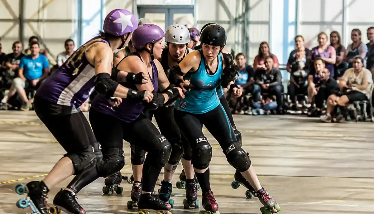 Match intense de roller derby en France avec joueuses en pleine action sur piste intérieure