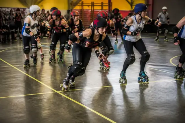 Joueurs en action sur la piste de roller derby pendant une compétition dynamique