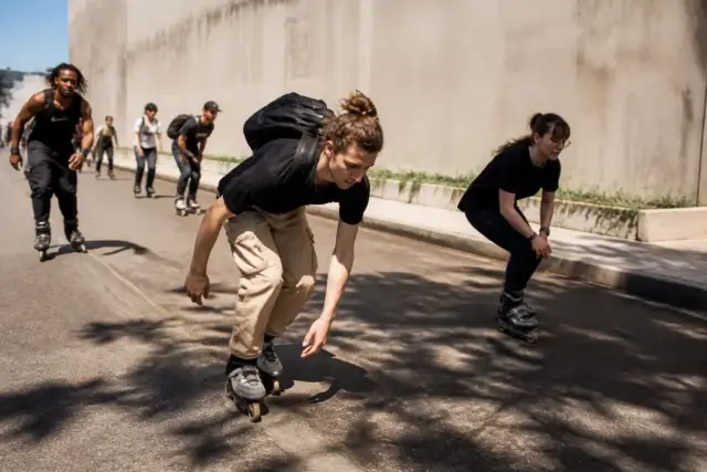Groupe de jeunes pratiquant le sport en roller sur une route urbaine